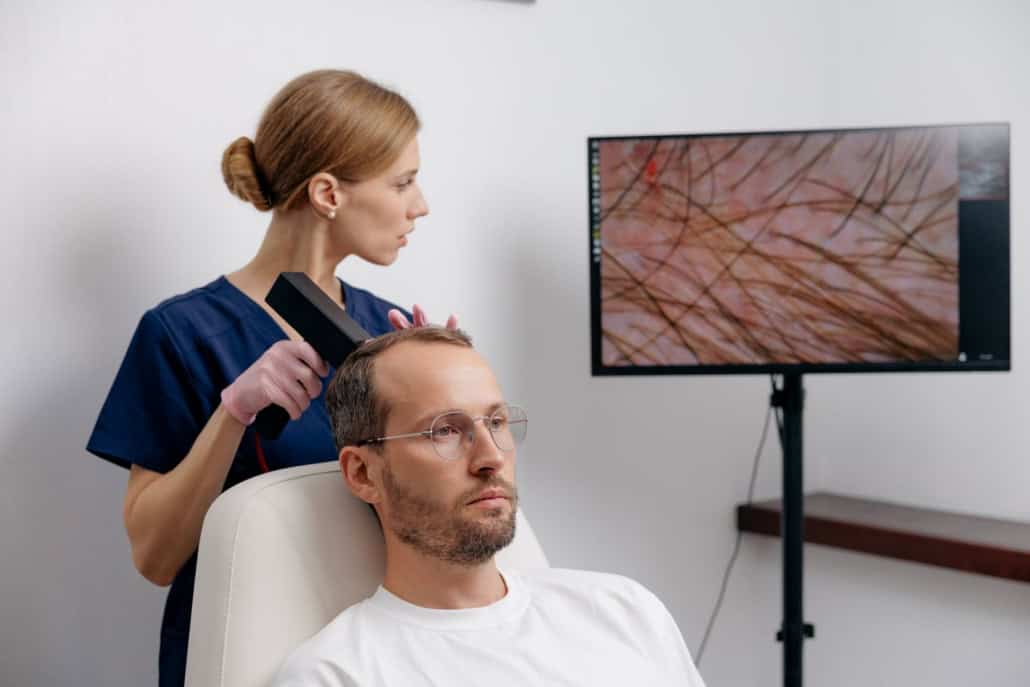 Hair transplant consultation in Milwaukee: clinician performing a digital scalp analysis of a patient's thinning hairline