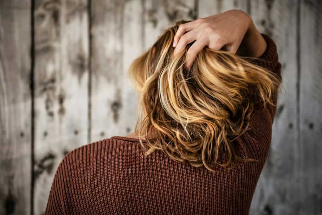 Woman with thinning hair at her part, a common candidate for PRP hair treatment